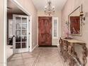 Entryway featuring a dark wood front door, chandelier, and a mirrored table at 25845 N 44Th Ave, Phoenix, AZ 85083