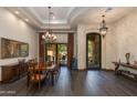 Elegant dining room with dark wood floors, a chandelier, and access to the outdoor patio at 26156 N 88Th Way, Scottsdale, AZ 85255