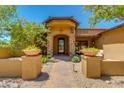 Inviting home entrance with stone accents, a custom iron door, and desert landscaping at 26156 N 88Th Way, Scottsdale, AZ 85255