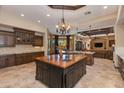 Gourmet kitchen featuring dark wood cabinets, granite countertops, and a central island at 26156 N 88Th Way, Scottsdale, AZ 85255