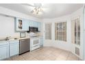 A bright kitchen with light blue cabinetry, stainless steel appliances, and an eat-in area next to a window at 3134 E Mckellips Rd # 139, Mesa, AZ 85213