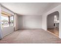 Bright, empty living room with carpet and a large window offering pleasant views at 4106 W Mission Ln, Phoenix, AZ 85051