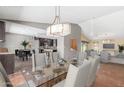 Open-concept dining area with modern chandelier, connecting kitchen and living spaces at 4233 W Michigan Ave, Glendale, AZ 85308
