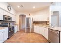 Well-lit kitchen with stainless steel appliances, tile backsplash, and granite countertops at 43612 W Chambers Ct, Maricopa, AZ 85138