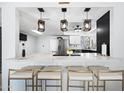 Modern kitchen boasts quartz countertops, counter seating, and stainless appliances at 5004 W Kaler Dr, Glendale, AZ 85301