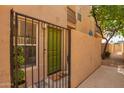 Gated entry to a condo with a green door, window, and small plant creating an inviting and private entrance at 5015 E Cheyenne Dr # 31, Phoenix, AZ 85044
