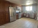 Bright kitchen with stainless steel appliances, granite countertops, and dark wood cabinetry at 520 W Mcneil St, Phoenix, AZ 85041