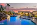 Backyard oasis with a large pool, waterfall, slide, and covered seating area at 5511 N 128Th Dr, Litchfield Park, AZ 85340