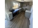 Modern kitchen showcasing stainless steel appliances, granite countertops, and wood flooring at 5723 N 44Th Ln, Glendale, AZ 85301