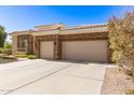 Attractive home showcasing a spacious driveway leading to a two-car garage and desert landscaping at 621 W Desert Ave, Gilbert, AZ 85233