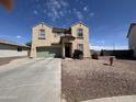 Spacious two-story home with a two-car garage and low-maintenance desert landscaping creating a welcoming curb appeal at 703 N Redwood Ln, Buckeye, AZ 85326