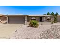 Charming single-story home featuring desert landscaping, gray brick accents and covered front entry at 7904 E Madero Ave, Mesa, AZ 85209