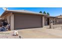 Exterior of home with a gray garage door with a long driveway and some trash cans at 7904 E Madero Ave, Mesa, AZ 85209