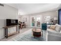 Bright living room with a modern rug, gray sofa, and glass patio doors at 7915 E Keim Dr, Scottsdale, AZ 85250