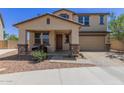Charming two-story home featuring a covered porch, a two car garage, and low maintenance landscaping at 8737 E Nichols Ave, Mesa, AZ 85209