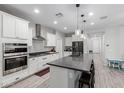 Bright and airy kitchen boasting white cabinets, a large center island, and stainless steel appliances at 8737 E Nichols Ave, Mesa, AZ 85209