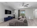 Cozy living room featuring a sectional sofa, a ceiling fan, and a sliding glass door to the backyard at 8737 E Nichols Ave, Mesa, AZ 85209