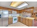 Kitchen featuring a full suite of appliances, tile flooring, and wood cabinets at 8741 W Osborn Rd, Phoenix, AZ 85037