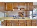 Traditional kitchen with wood cabinets, neutral countertops, and a double basin stainless steel sink at 8741 W Osborn Rd, Phoenix, AZ 85037