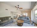 Bright living room features neutral walls, plush sofas, a ceiling fan and an open view to the kitchen and dining area at 964 Leisure World --, Mesa, AZ 85206