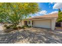 Well-maintained single-story home featuring an attached two-car garage and desert landscaping at 1002 E Topeka Dr, Phoenix, AZ 85024