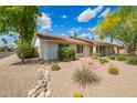 Attractive single-story home with xeriscaping and a stone-lined dry creek bed at 1002 E Topeka Dr, Phoenix, AZ 85024