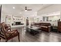Spacious living room featuring a white-painted brick fireplace and dark wood-look flooring at 1002 E Topeka Dr, Phoenix, AZ 85024