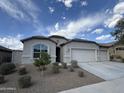 Charming single-story home with a three car garage, desert landscaping, and a neutral color palette at 10736 W Swayback Pass, Peoria, AZ 85383