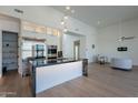 Bright, modern kitchen with black marble island and countertops, wood floors, stainless steel appliances, and pendant lighting at 14141 E Highland Ave, Fountain Hills, AZ 85268