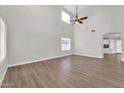Spacious living room with tall ceilings, neutral paint, wood-look floors, and natural light at 14200 W Larkspur Dr, Surprise, AZ 85379