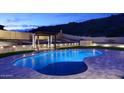 An inviting backyard pool with ambient lighting, creating a tranquil oasis for relaxation and entertaining under the night sky at 14552 S 182Nd Dr, Goodyear, AZ 85338