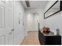Neutral hallway with an arched doorway, wood decor, and a dark wood storage cabinet at 14575 W Mountain View Blvd # 11220, Surprise, AZ 85374