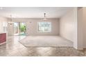 Spacious living room with plush carpeting, ceiling fan, and bright natural light from sliding glass doors at 18072 W Paradise Ln, Surprise, AZ 85388