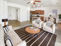 Bright living room features an open floorplan with a view of the kitchen and an abundance of natural light at 18207 W Marshall Ln, Surprise, AZ 85388
