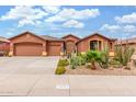 Exterior shot of a well-maintained house with a three-car garage and desert landscaping at 18482 W Marconi Ave, Surprise, AZ 85388