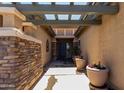 Welcoming covered entry featuring stacked stone accents and decorative potted plants at 18775 E Seagull Dr, Queen Creek, AZ 85142