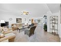 Spacious living room with neutral tones, ceiling fan, and an open floor plan at 21218 N Aurora Dr, Sun City West, AZ 85375