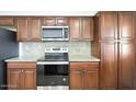 Updated kitchen featuring stainless steel appliances, granite counters, and custom cabinetry at 233 E Cairo Dr, Tempe, AZ 85282