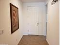 Bright entryway featuring a white door and tiled flooring complemented by a framed art piece at 2611 E San Paulo Dr, Casa Grande, AZ 85194