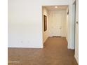 A well-lit home entryway with ceramic tile floors, an adjacent dining area and a white front door at 2611 E San Paulo Dr, Casa Grande, AZ 85194