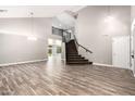Bright living room showcasing wood-look tile flooring, a staircase, and soaring ceilings at 34949 N Spur Cir, San Tan Valley, AZ 85144