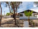 Charming home with white brick, black trim, desert landscaping, and a wrought iron fence at 3802 N 48Th Dr, Phoenix, AZ 85031