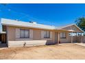 Side view of a single-story home featuring an open front yard under a clear blue sky at 4636 W Mission Ln, Glendale, AZ 85302