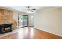 Bright living room with laminate floors, stone fireplace, and sliding door access to a balcony at 4850 E Desert Cove Ave # 240, Scottsdale, AZ 85254