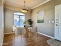 This dining area features a round glass table, modern chandelier and a large picture window at 5335 E Shea Blvd # 2045, Scottsdale, AZ 85254