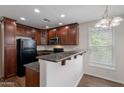 Cozy kitchen featuring granite countertops, dark wood cabinetry, and modern appliances at 5628 S 21St Pl, Phoenix, AZ 85040