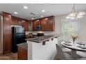 Cozy kitchen featuring granite countertops, dark wood cabinetry, and modern appliances adjacent to dining space at 5628 S 21St Pl, Phoenix, AZ 85040