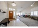Bright foyer leading into a spacious living room with vaulted ceilings, large windows and tile-carpet flooring at 6135 E Aire Libre Ln, Scottsdale, AZ 85254