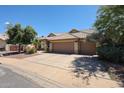 Attractive single-Gathering home featuring a large driveway, well-manicured yard, and an attached two-car garage at 6135 E Aire Libre Ln, Scottsdale, AZ 85254
