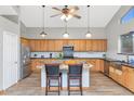 Well-equipped kitchen with stainless steel appliances, wood cabinets and a center island at 648 W Cobblestone Dr, Casa Grande, AZ 85122